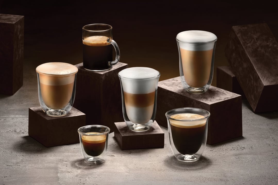 Six different coffee drinks in glass cups on dark brown blocks