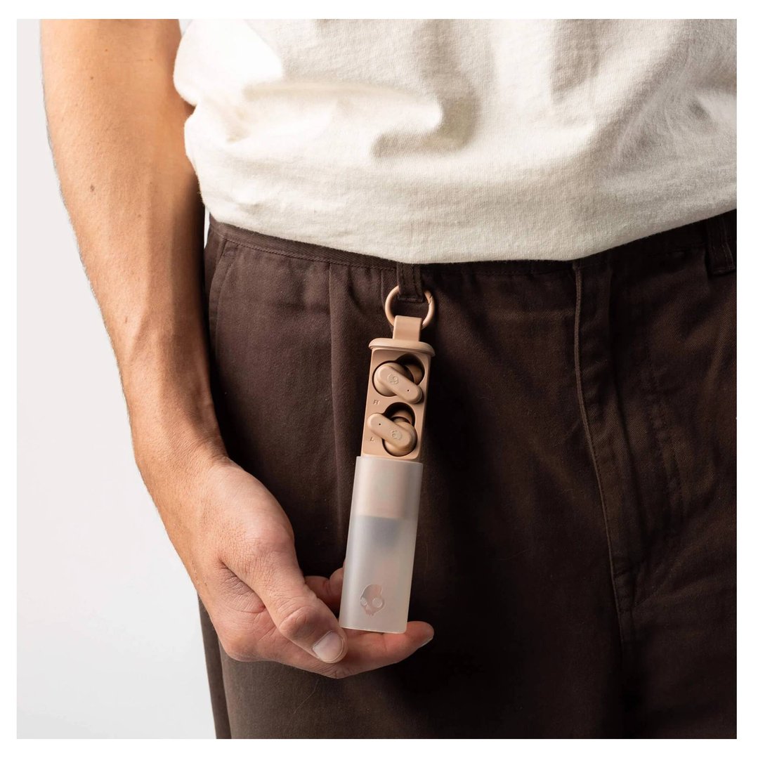 Person holding Skullcandy Dime Evo TWS In-Ear Primer headsets attached to pants
