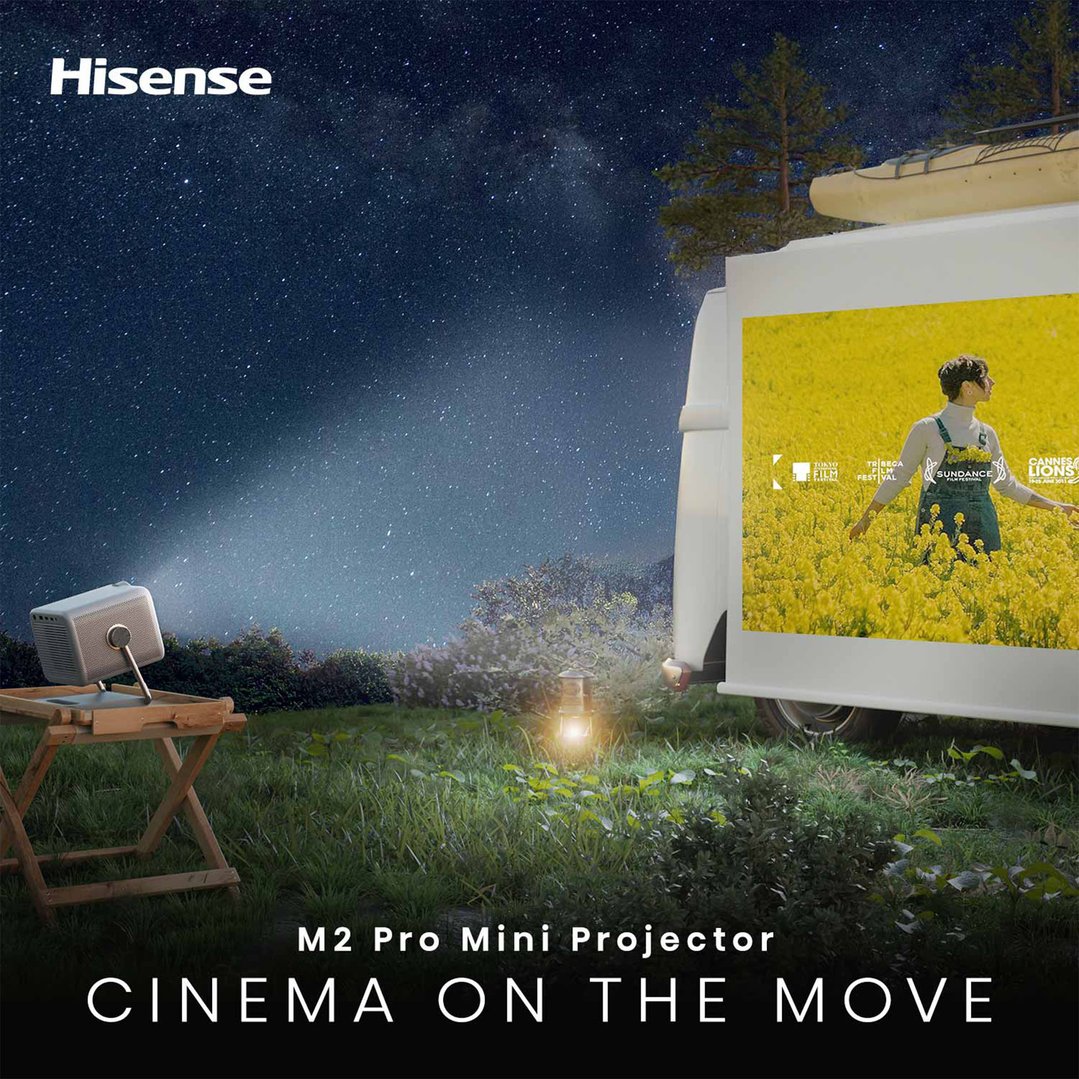 Projector displaying a movie on a camper van in an outdoor night scene
