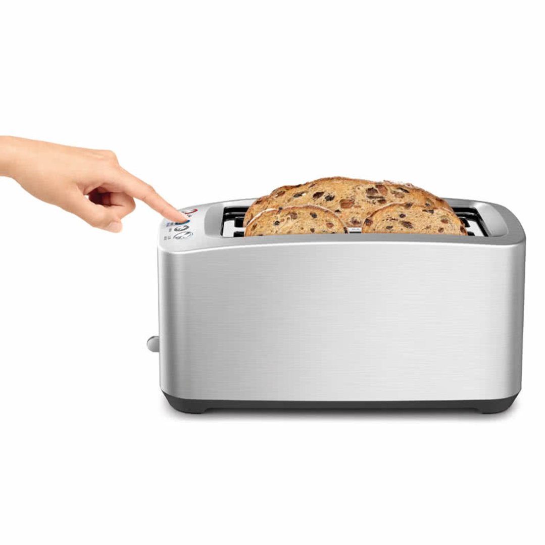 Hand pressing button on a silver toaster with raisin bread inside