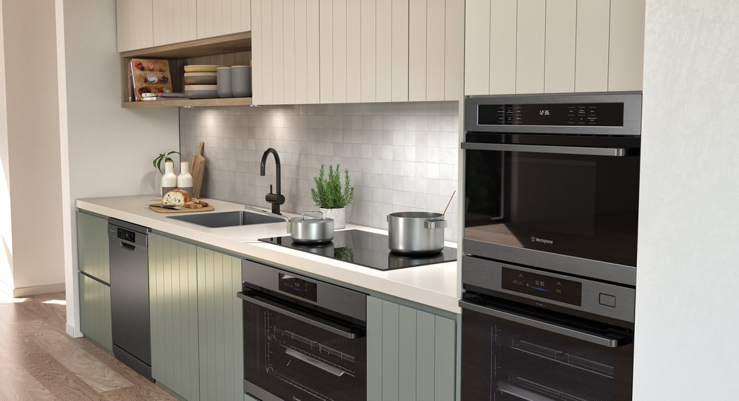 Two ovens and a cooktop integrated into a modern kitchen with green cabinetry
