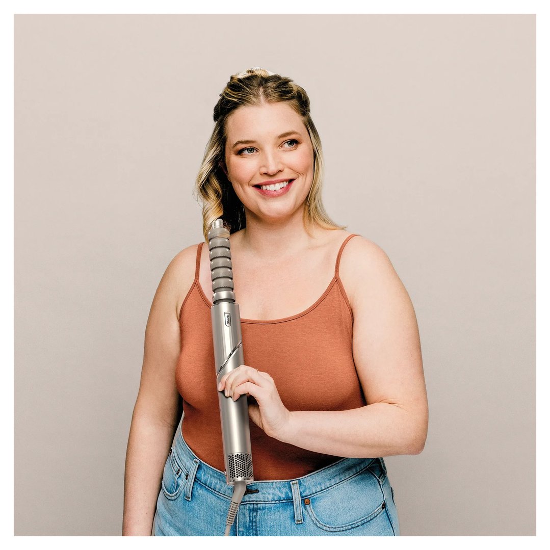 Woman holding a Shark FlexStyle Air Styling & Drying System to her hair