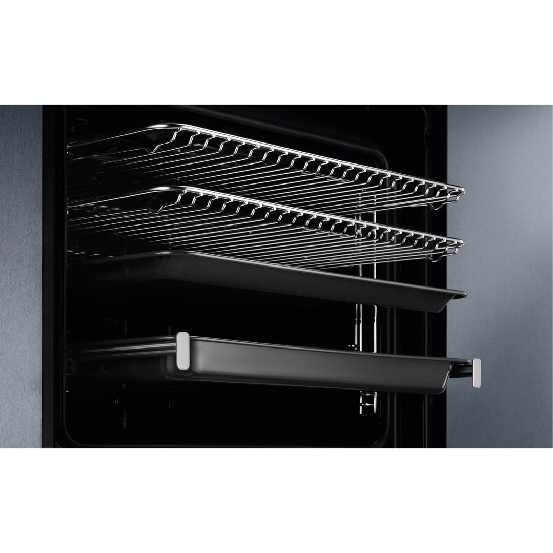 Close up of the inside of an oven with two racks and two baking trays