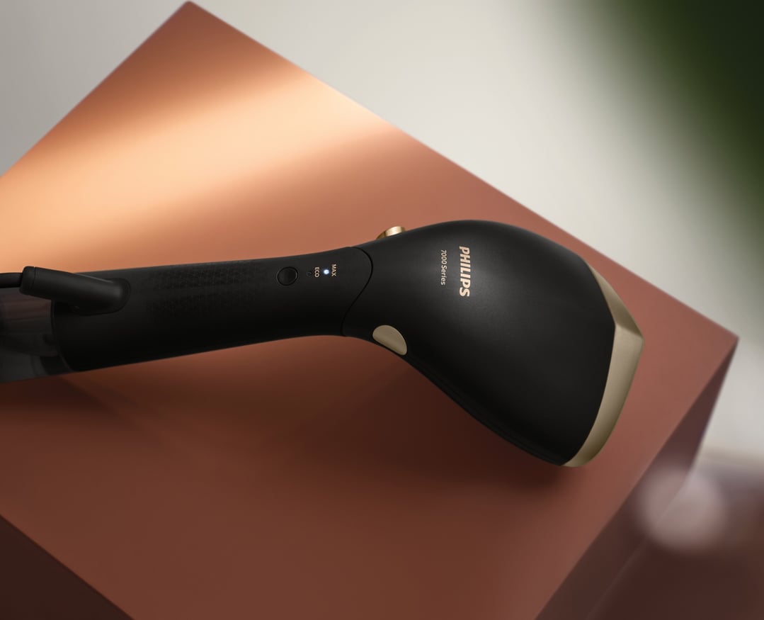 Black Philips 7000 Series handheld garment steamer on a brown and white surface