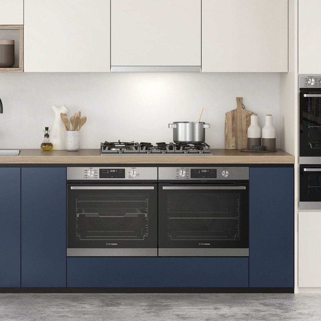 A 75cm 5 burner gas cooktop in a modern kitchen with blue cabinets