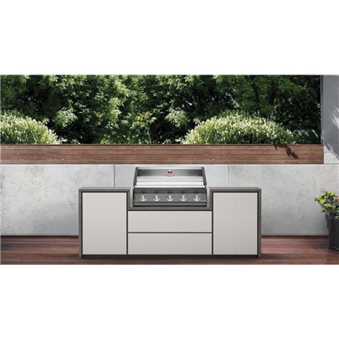 Built-in 5 burner barbeque in an outdoor kitchen setting with greenery