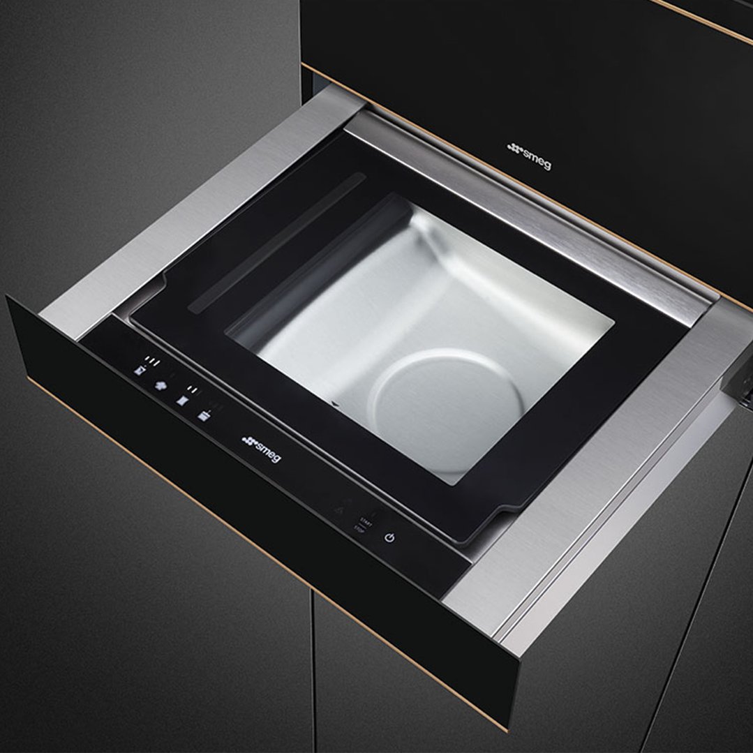 A Smeg warming drawer, partially open, showing its stainless steel interior
