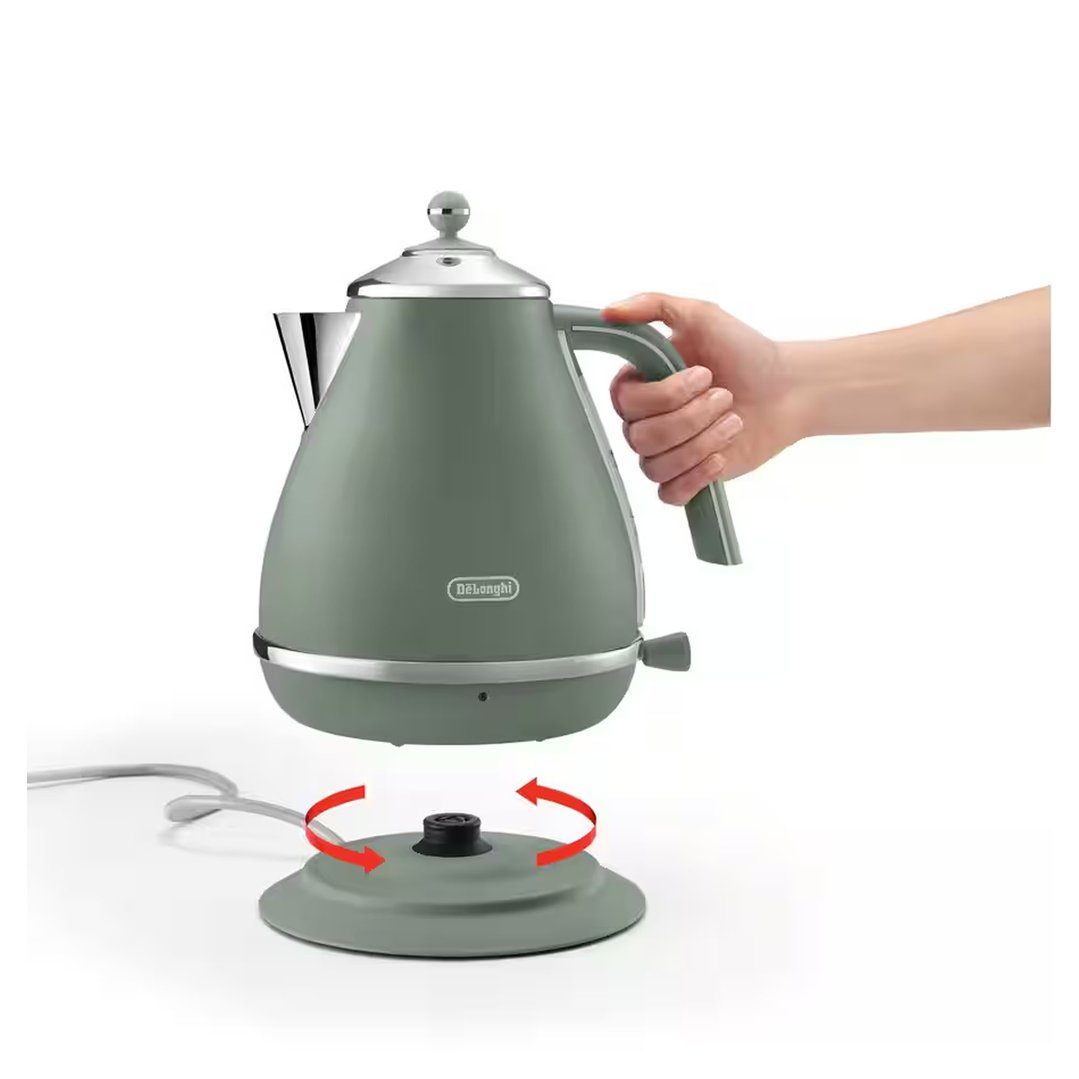 Hand placing a green DeLonghi kettle onto its rotating base