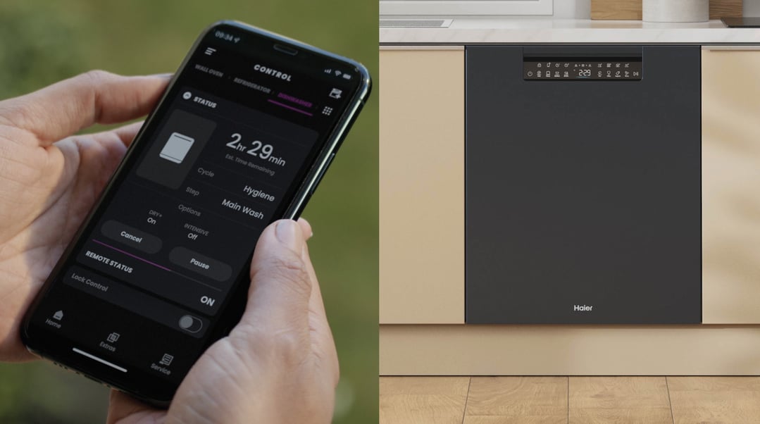 Hand holding a smartphone displaying a dishwasher control app next to a dishwasher