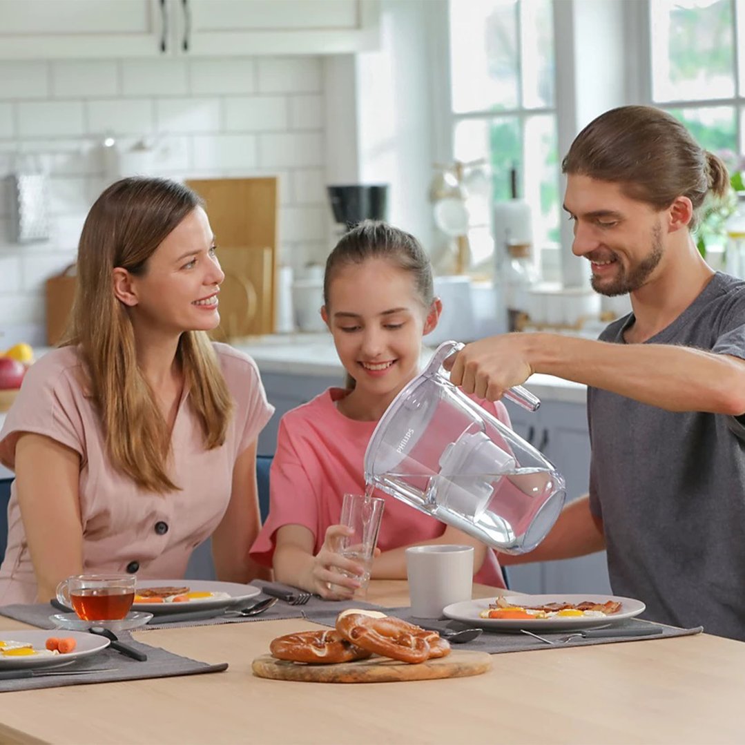Man pouring water from a water jug for a family breakfast