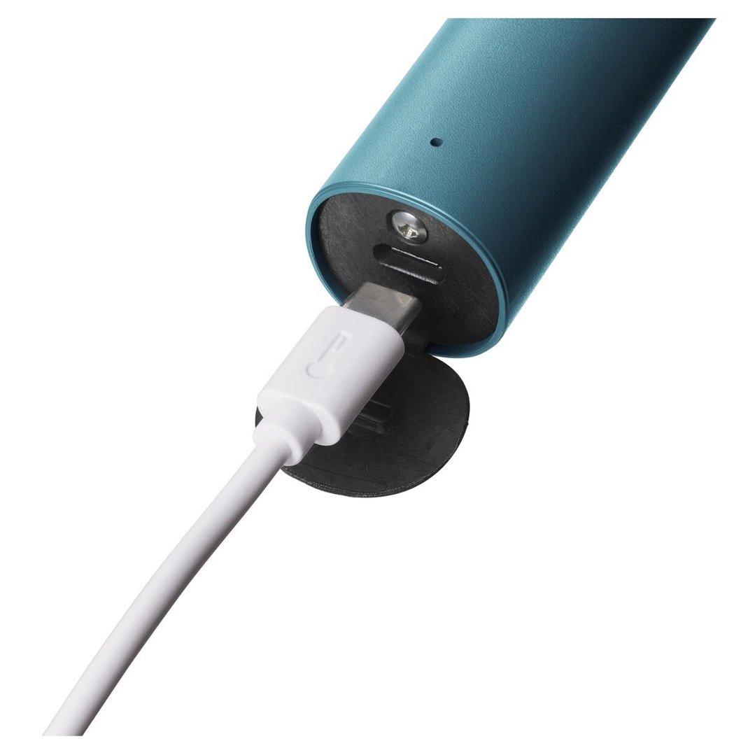 Close-up of a blue electric shaver charging with a white USB-C cable