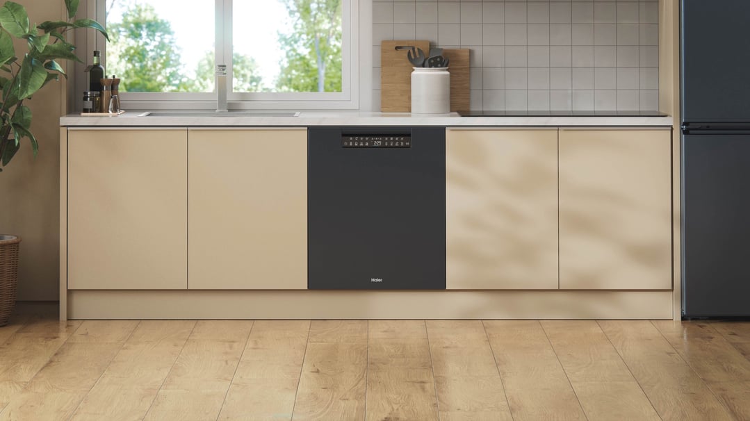 Black built-under dishwasher in a modern kitchen with light wood flooring
