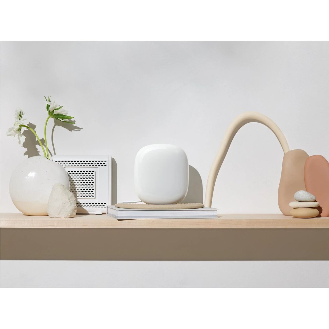 Nest WiFi Pro 6E on a shelf with decorative items and flowers