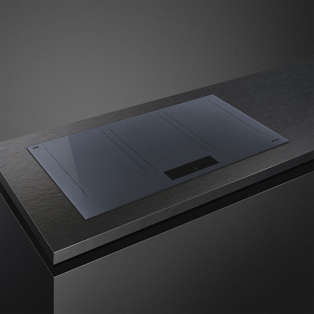 Induction cooktop built into a dark countertop in a modern kitchen setting