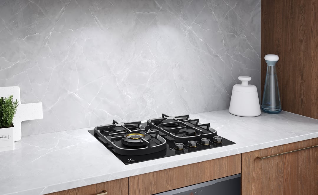Black ceramic glass gas cooktop in a modern kitchen with marble backsplash