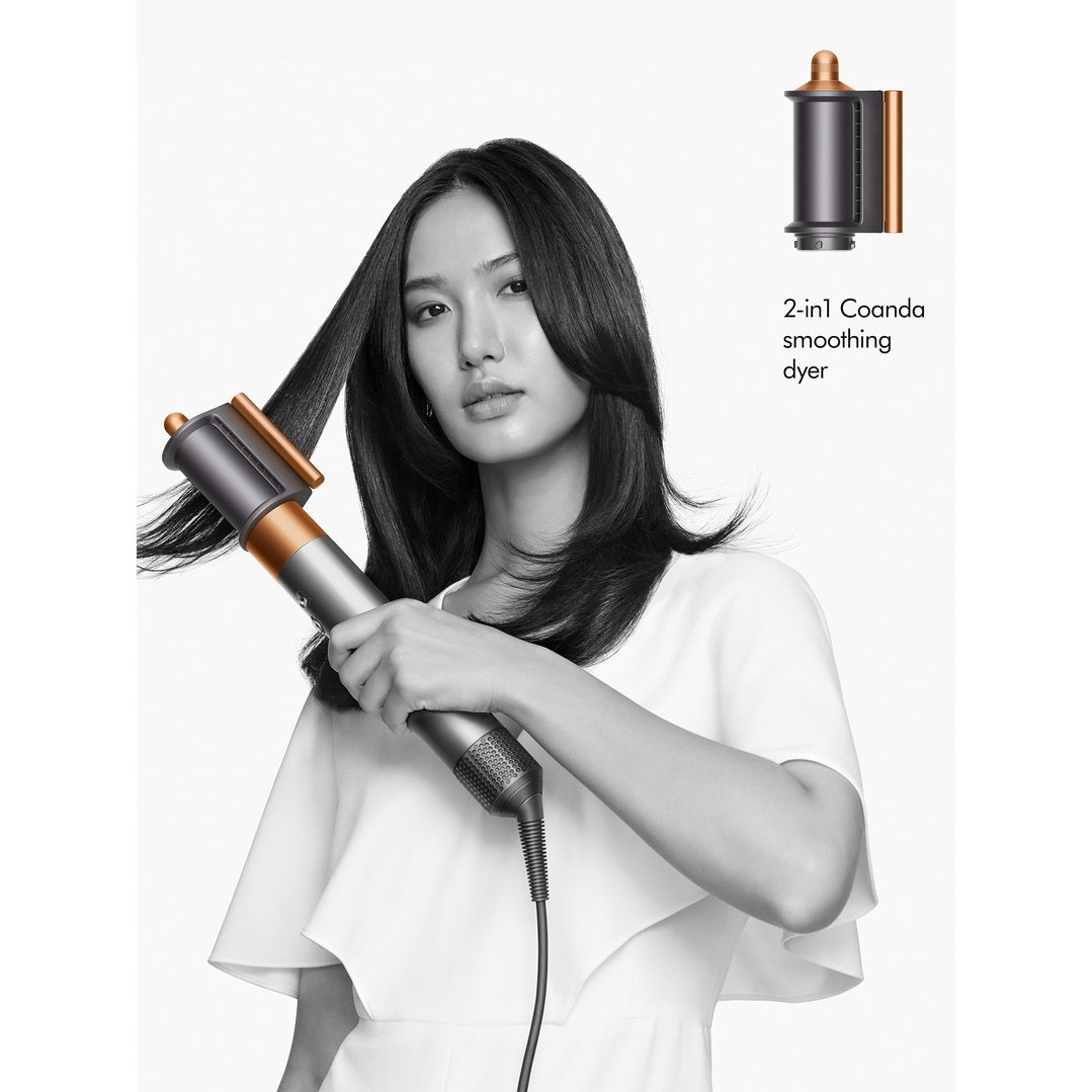 Woman styling her hair with a Dyson Airwrap multi-styler and dryer