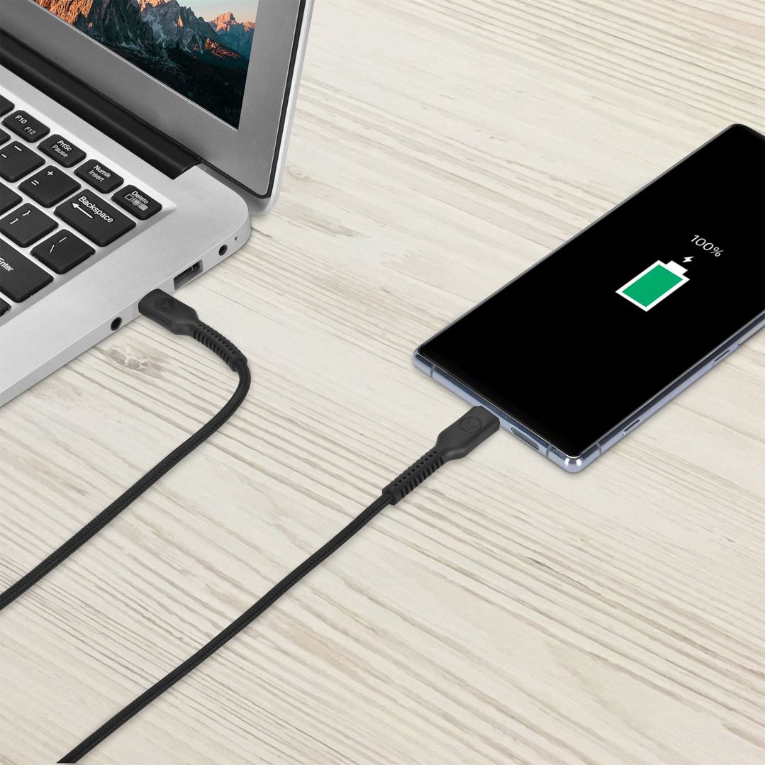 Black USB-C cable connecting a laptop to a smartphone on a wooden surface