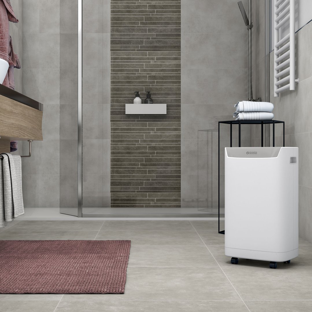 White dehumidifier on wheels in a modern bathroom with grey tiles