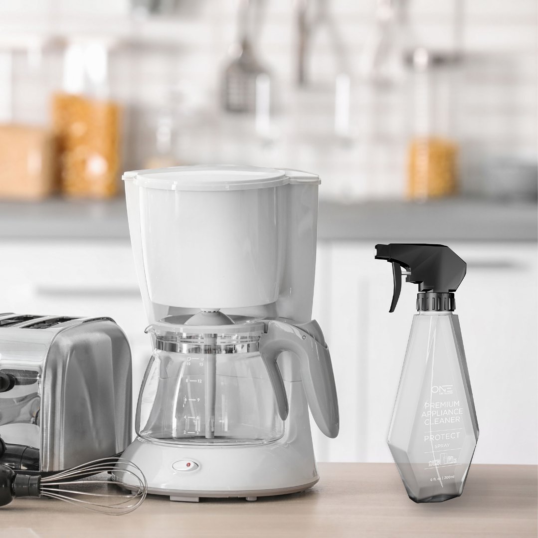 Premium appliance cleaner spray bottle on a kitchen counter with appliances