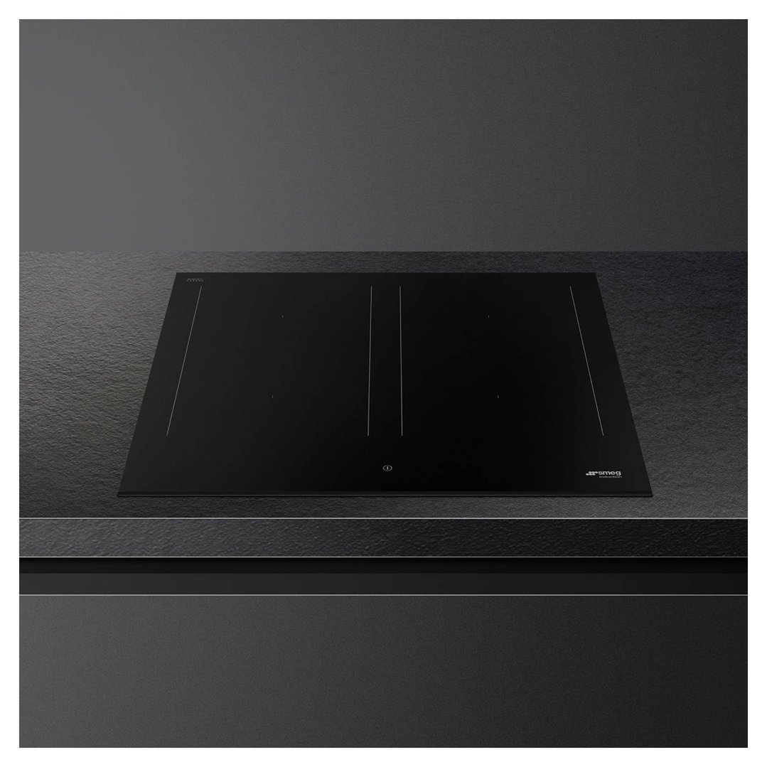Black induction cooktop built into a dark countertop in a modern kitchen
