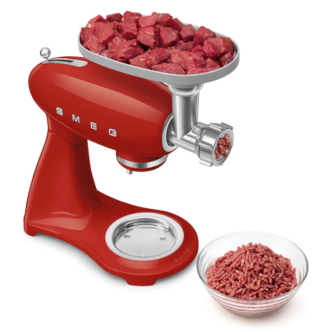 Red Smeg stand mixer with meat grinder attachment processing meat