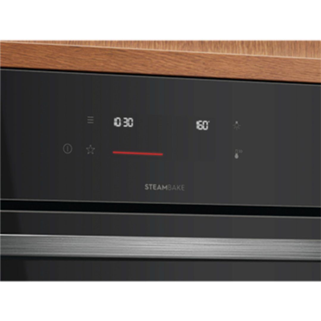 Close up of a black oven control panel with digital display and "STEAMBAKE" text