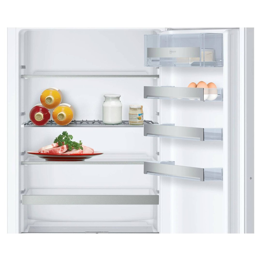 Open integrated fridge interior with food items on shelves and in door bins