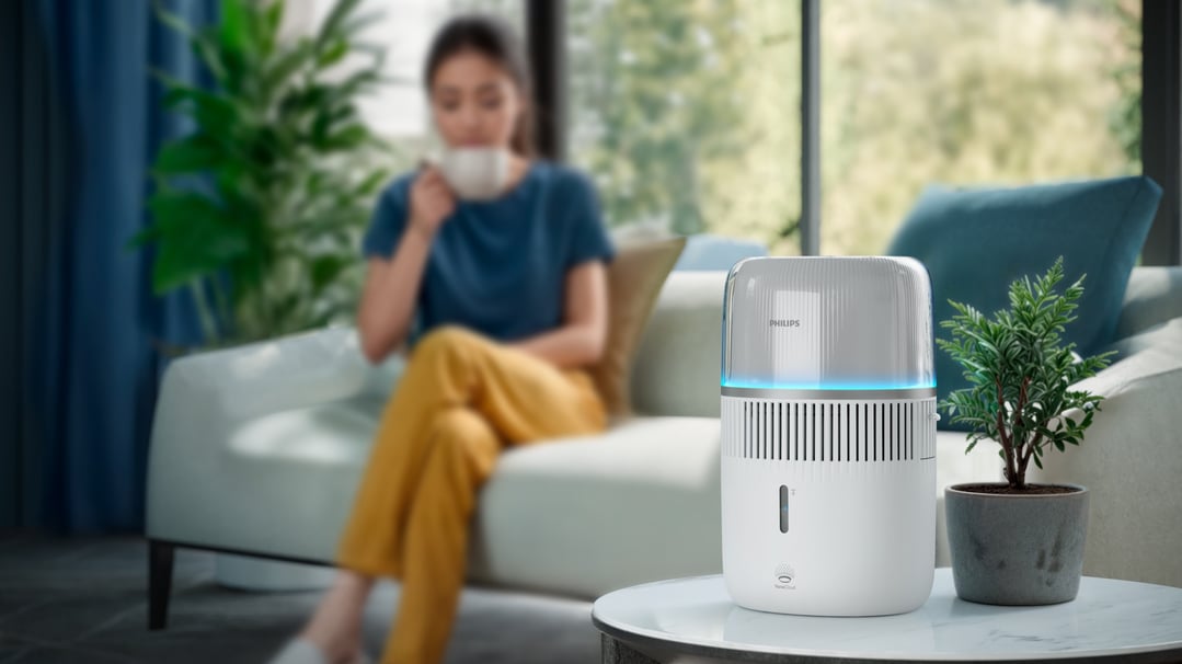 Philips Series 5000 Evaporative Humidifier on a table with a woman in the background