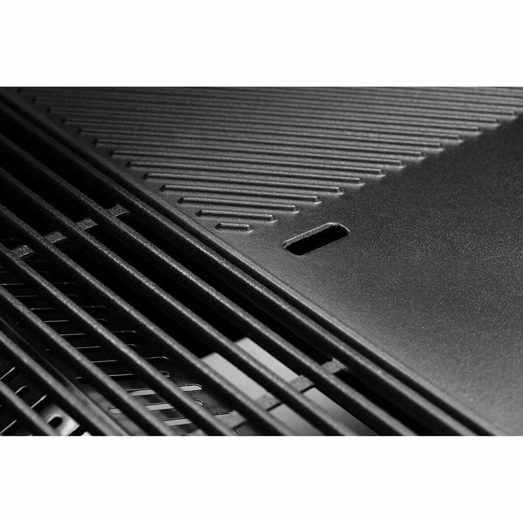 Close up of the black grates and flat plate of a built-in barbecue