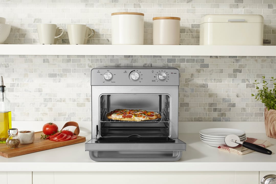 Multi Function Oven + Air Fryer with pizza inside on a kitchen counter