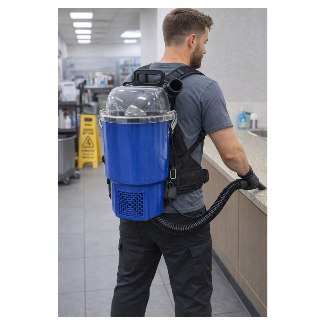Man wearing a backpack vacuum cleaner, cleaning a counter in a commercial setting