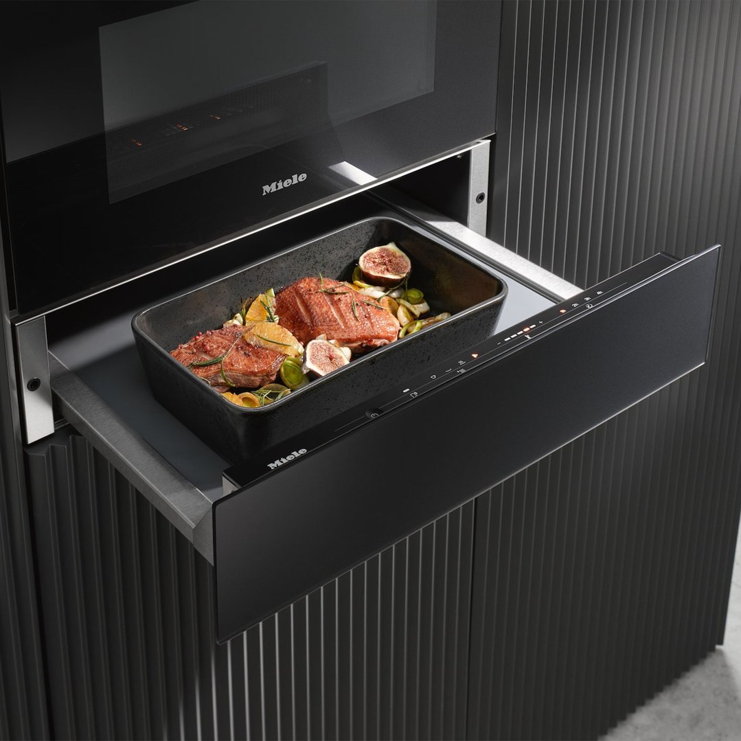 Miele Gourmet Warming Drawer with a dish of food in a styled kitchen setting