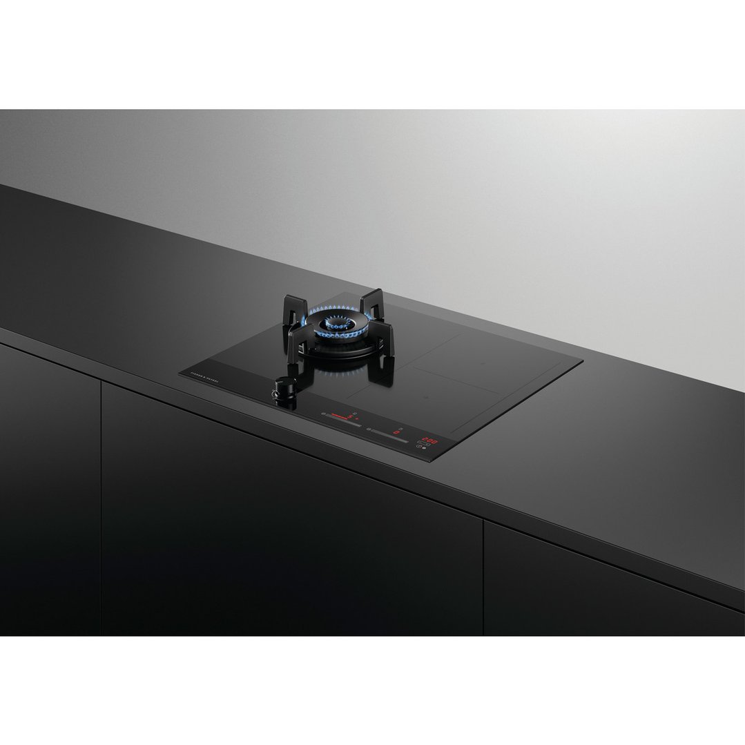 Black hybrid cooktop with gas burner and induction zones on a dark countertop