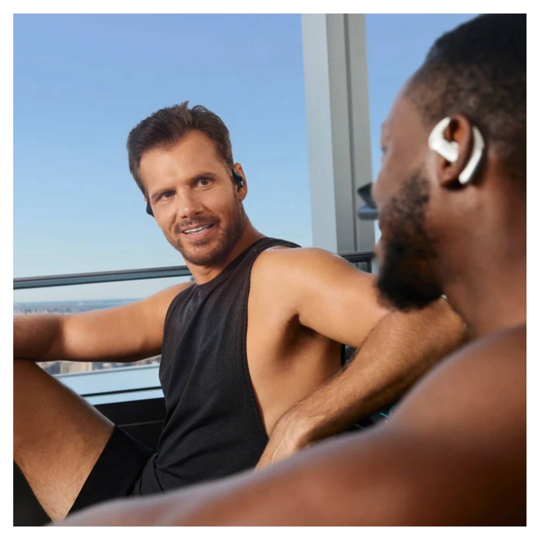 Two men wearing OpenFit Pro Wireless Open-Ear Wireless Headphones in a gym setting