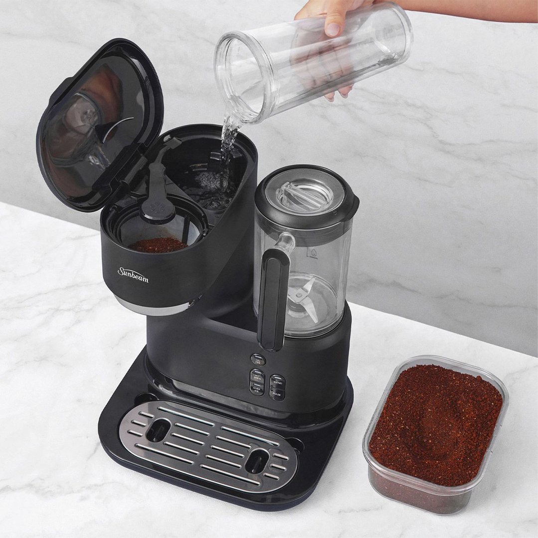 Hand pouring water into a Sunbeam Frappe Iced + Hot Coffee Machine