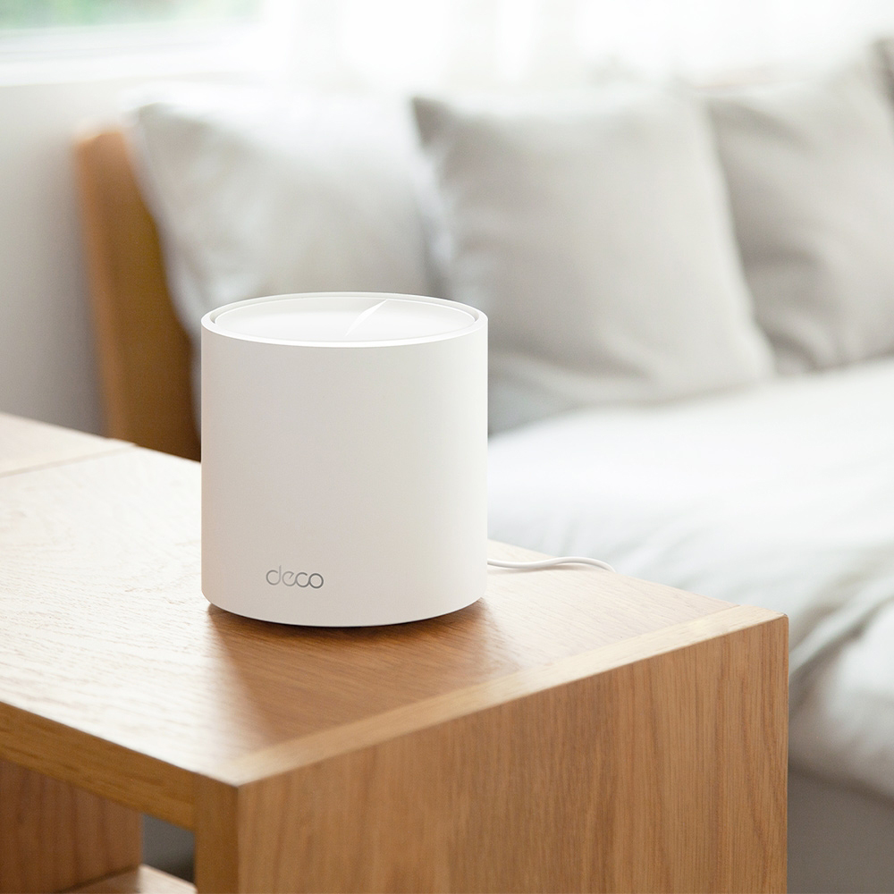 White mesh WiFi 6 router on a wooden bedside table in a bedroom