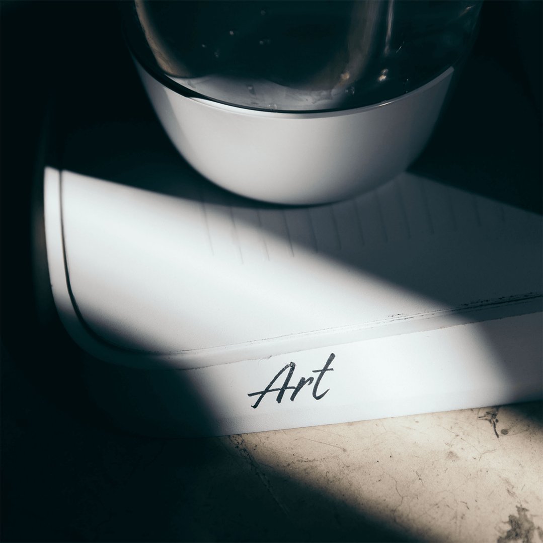 White Art Sparkling Water Maker on a surface with a shadow across it