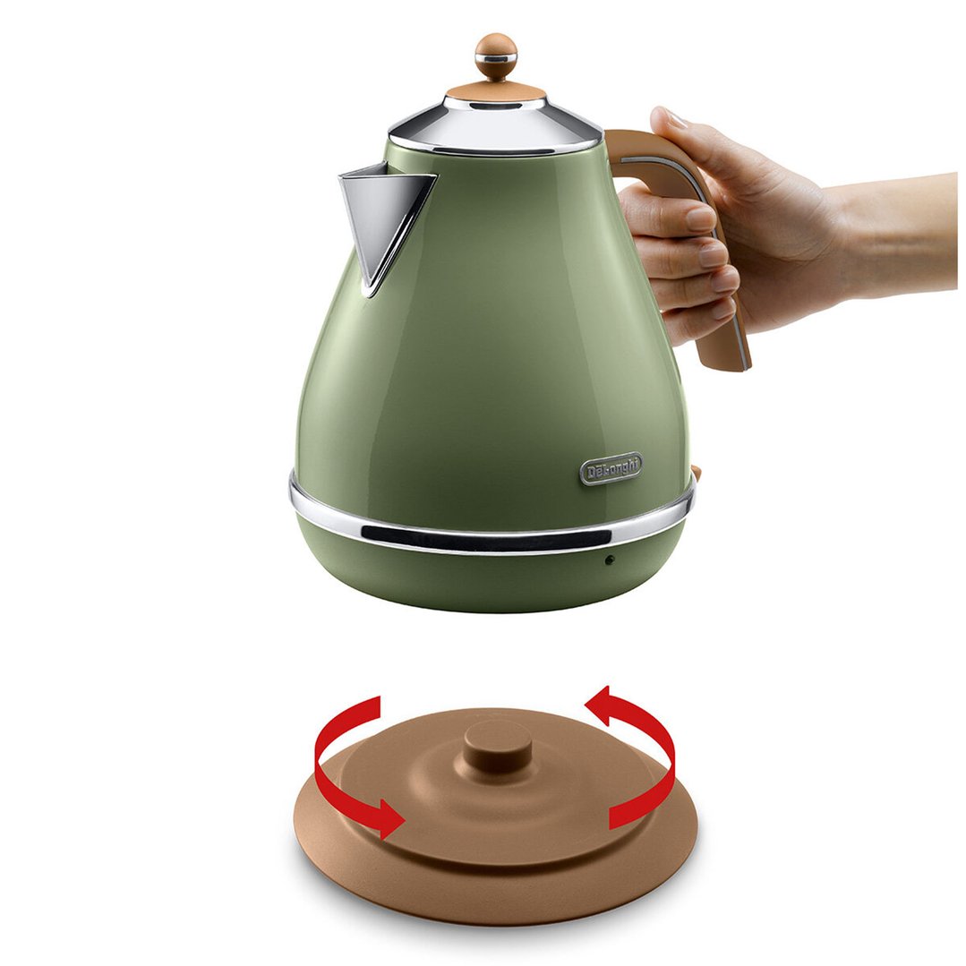 Hand holding a green kettle above its rotating base with arrows