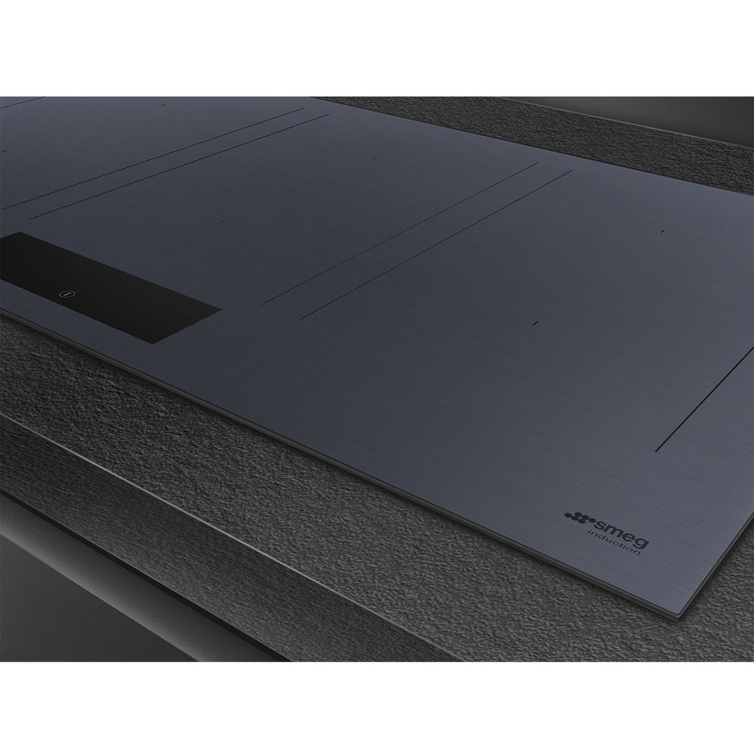 Close-up of a dark grey induction cooktop integrated into a dark countertop