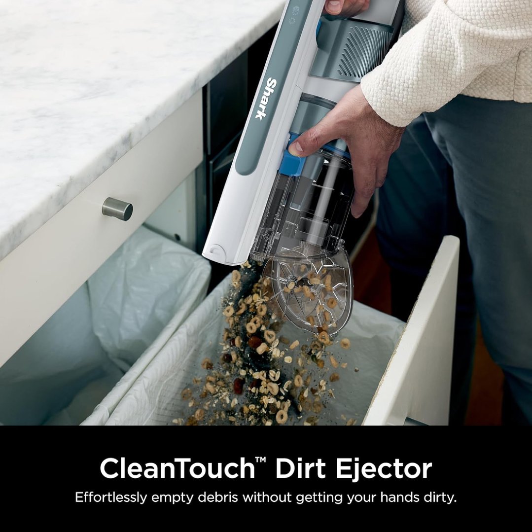 Handheld cordless stick vacuum emptying debris into a trash can