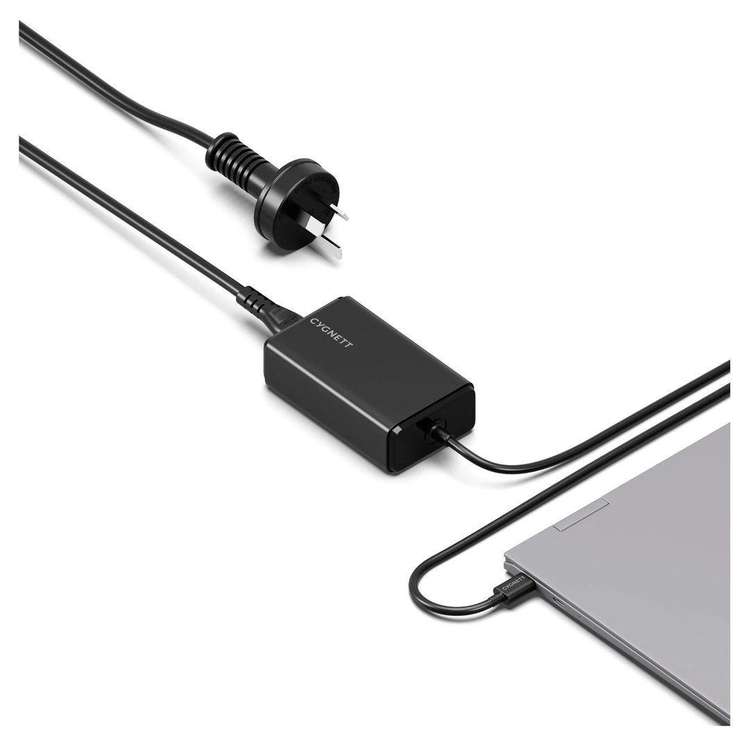 Black Cygnett laptop charger connected to a laptop on a white surface