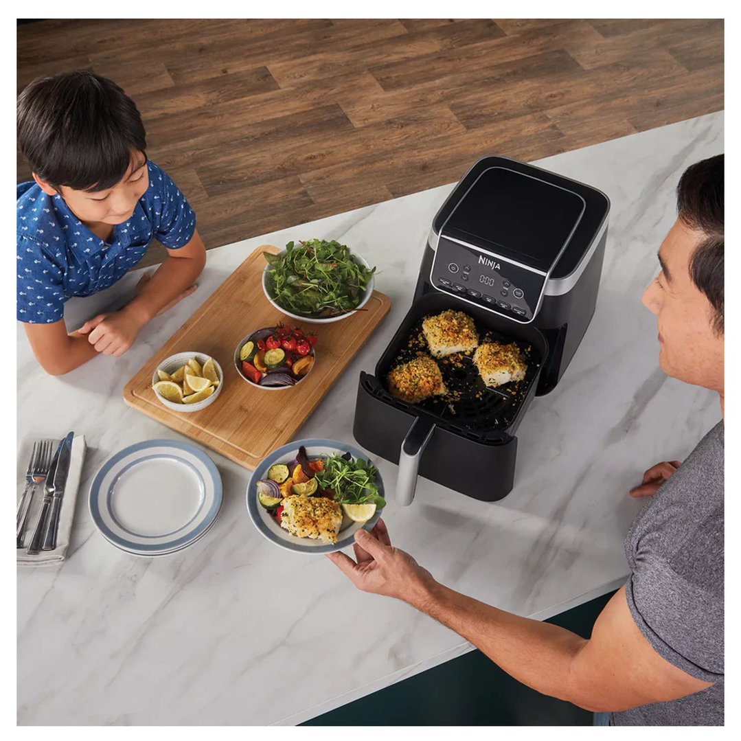 Man serving food from an Air Fryer Pro XL to a boy