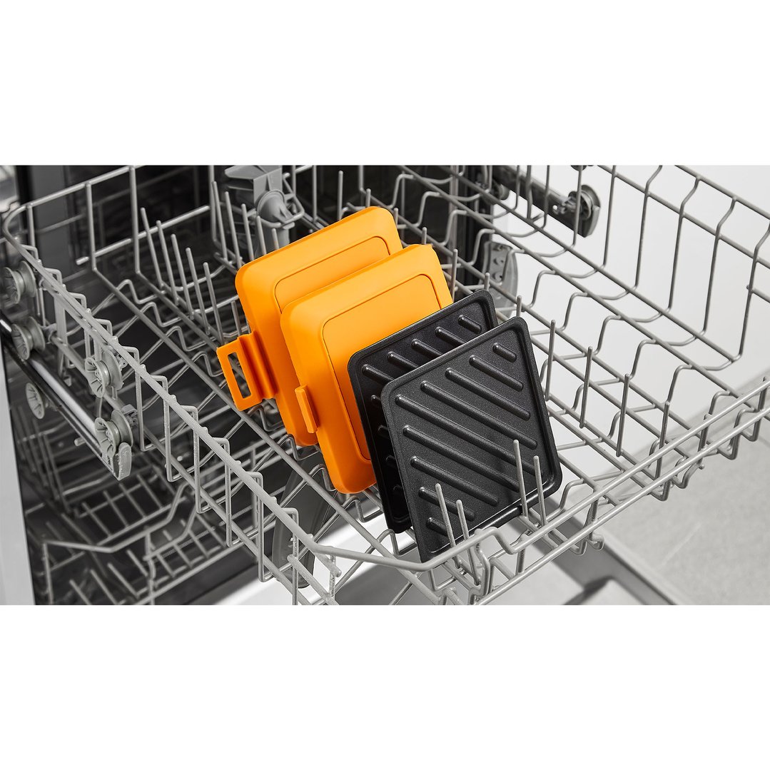 Two orange and two black sandwich makers in a dishwasher rack