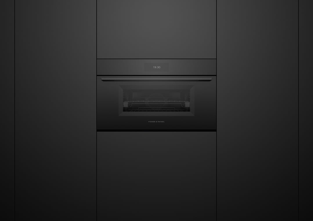 Black compact combi-steam oven built into dark cabinetry, displaying 19:30 on screen