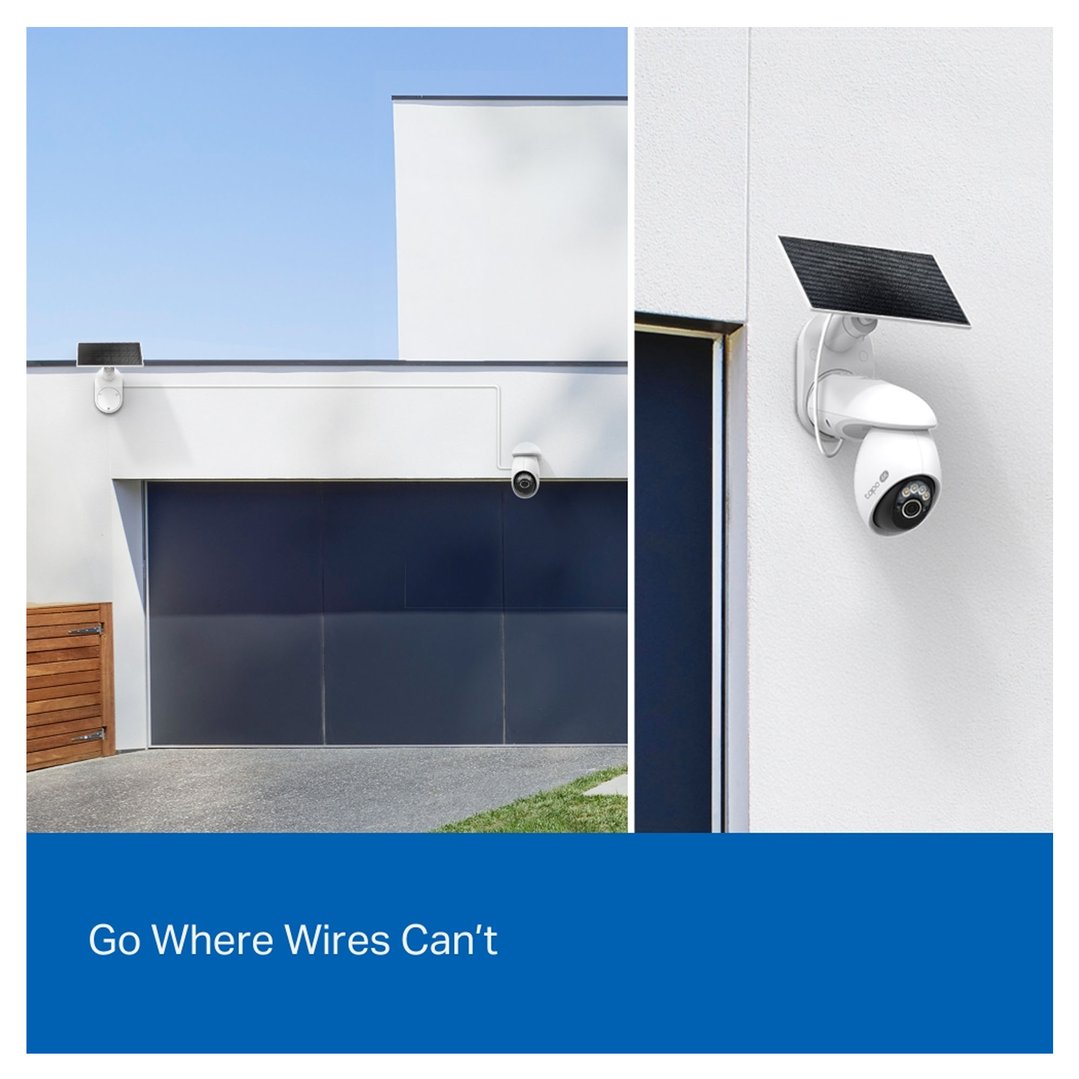 Two security cameras with solar panels mounted on a modern house exterior