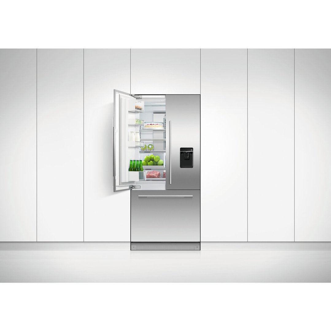Stainless steel French door refrigerator freezer with one door open in a white kitchen