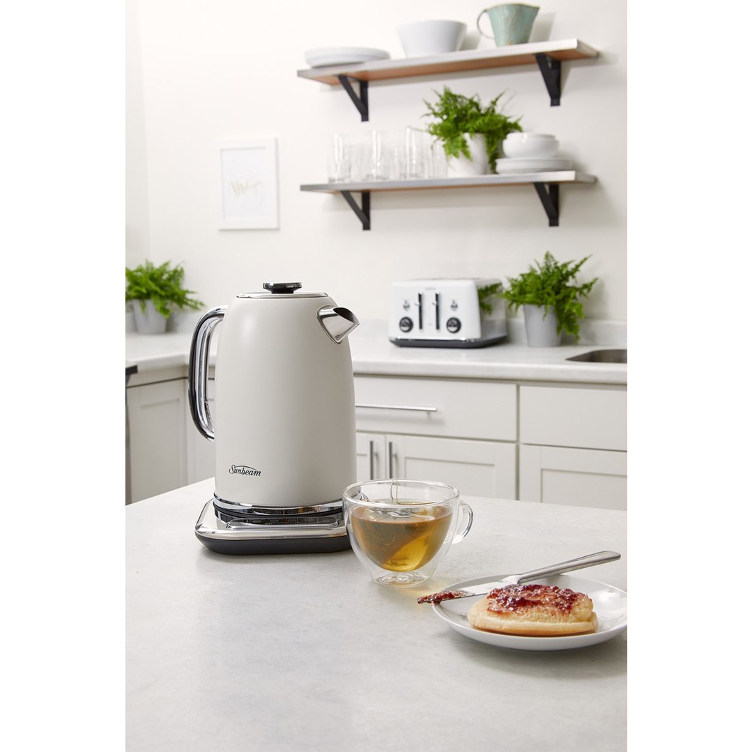 White Sunbeam kettle on a kitchen counter with a cup of tea and scone