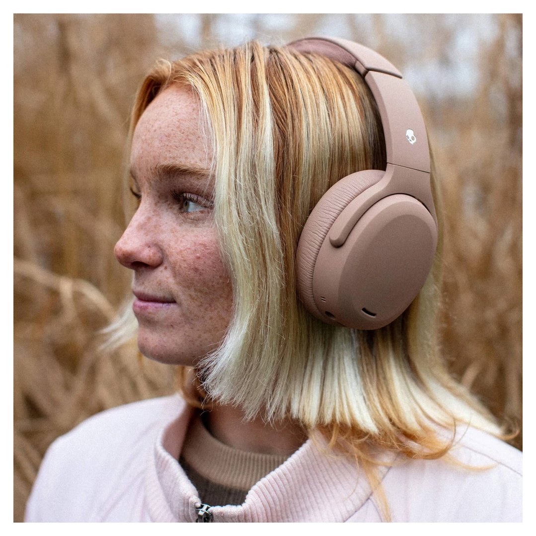 Woman with blonde hair wearing Skullcandy Crusher ANC 2 headphones outdoors