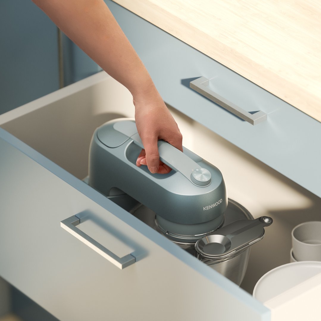 Hand placing a Kenwood Go Stand Mixer into a kitchen drawer