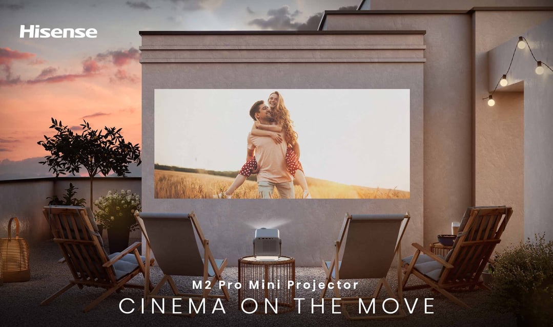 M2 Pro Mini Projector displaying a movie on an outdoor patio at sunset